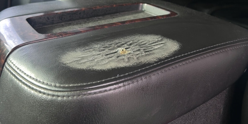 Before: worn scuffed patch on vinyl center console lid